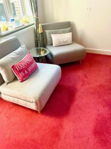 a living room with two chairs and a red carpet at The Quay in Newhaven