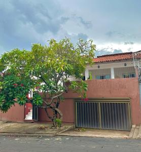 un edificio con una puerta y un árbol delante de él en Casa de hospedagem Ferreira - Renascença, en São Luís