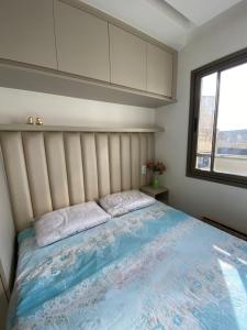 Un dormitorio con una cama grande y una ventana en Estúdio com Decoração Charmosa e Piscina compart, en Salvador