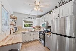 a kitchen with white cabinets and a stainless steel refrigerator at Rare City Home w/ Backyard Fire-pit & Hottub in Lancaster