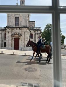 dos personas montando caballos en frente de un edificio viejo en Luxury Artistic Digital Nomad Getaway w/ Terrace en Lisboa