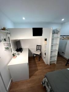 Kleines Zimmer mit einem Bett und einem Schreibtisch mit einem Computer. in der Unterkunft Luxury Artistic Digital Nomad Getaway w/ Terrace in Lissabon