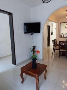 uma sala de estar com uma mesa e uma televisão na parede em Casa En El Centro Histórico De Morelia em Morelia