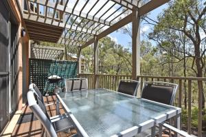 a table and chairs on a deck with a pergola at Villa 2br Barbera Villa located within Cypress Lakes Resort in Pokolbin