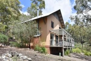 a house on a hill with a windmill at Villa 2br Barbera Villa located within Cypress Lakes Resort in Pokolbin