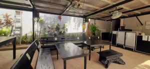 ein Zimmer mit einer Bank, Tischen und Pflanzen in der Unterkunft Ezekiel Transient House in Coron