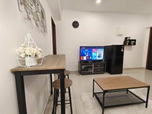 a living room with a table and a tv at 【NEW】Cozy&Warm Studio@Juru Sentral Icon City in Bukit Mertajam