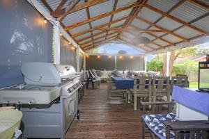 a patio with a stove and some tables and chairs at The Ultimate Holiday Retreat Pets Welcome in Tea Gardens +25 photos