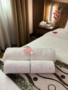 a hotel room with a bed with towels on it at Nova Hotel Miri in Miri