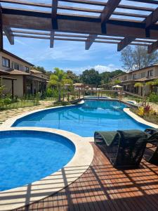 巴拉大的住宿－Condominio Viva Barra，庭院内一个带两把椅子的大型游泳池