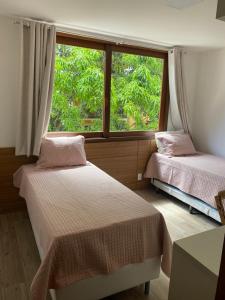2 Betten in einem Zimmer mit Fenster in der Unterkunft Condominio Viva Barra in Barra Grande