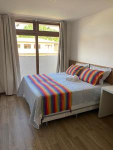sypialnia z łóżkiem i dużym oknem w obiekcie Condominio Viva Barra w mieście Barra Grande