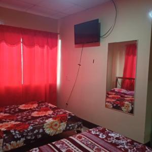 Cette chambre comprend 2 lits et une télévision murale. dans l'établissement HOTEL PRIMAVERA, à Guayaquil