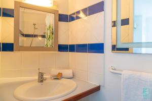 a bathroom with a sink and a mirror at Appartement en résidence proche de la plage - Le Mimosa in Sainte-Anne