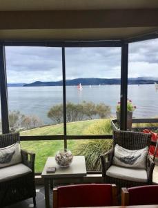 a room with a large window with a view of the water at Beach Buoy Opossum Bay in South Arm