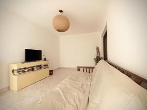 uma sala de estar com uma cama e uma televisão em Kau hostel & experiencias em Perito Moreno