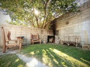 un patio con 2 sillas y chimenea en Kau hostel & experiencias en Perito Moreno