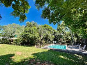 a fence around a pool in a yard at Kwila Cottage in Mission Beach