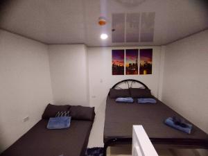 een kleine kamer met 2 bedden en een bank bij Minimalist Loft 107 in Baguio