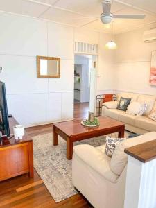 ein Wohnzimmer mit einem Sofa und einem Couchtisch in der Unterkunft Original Pier Beach Retreat - Child Pet Friendly in Urangan