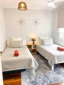 2 Betten in einem Zimmer mit weißen Wänden in der Unterkunft Original Pier Beach Retreat - Child Pet Friendly in Urangan