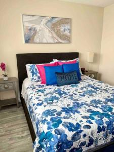 a bedroom with a bed with a blue and white comforter at SouthBAY Beaches Beauty&Cozy Apt in Gardena
