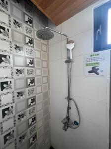 a shower in a bathroom with a wall covered in stickers at 今古安民宿 - 步行東大門夜市3分鐘 in Hualien City