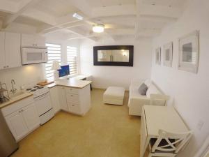 a white kitchen with a couch and a table at Cozy Beachfront Apartment with Bay views in East End
