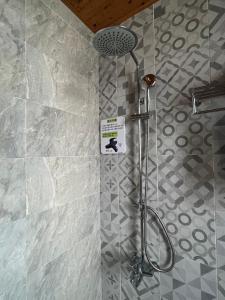 een badkamer met een douche met een bord aan de muur bij 今古安民宿 - 步行東大門夜市3分鐘 in Hualien