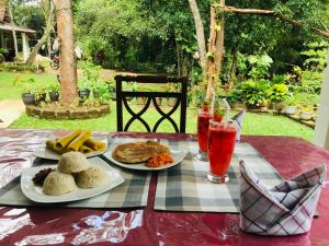 una mesa con dos platos de comida y bebida. en Holly Flowers Villa, en Sigiriya
