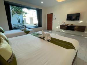 - une chambre dotée d'un grand lit avec un animal rembourré dans l'établissement Dark Sugar Resort, à Ban Bo Thong