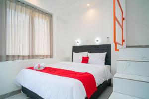 1 dormitorio con 1 cama grande con manta roja en RedDoorz near Stasiun Senen, en Yakarta