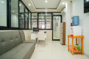 an office with a couch and a desk with a computer at RedDoorz near Stasiun Senen in Jakarta