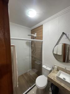 uma casa de banho com um WC, um chuveiro e um lavatório. em RM hospedagem em Cabo Frio