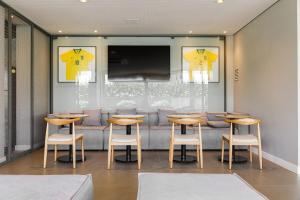 un restaurante con mesas y sillas de madera y TV en Patio Milano Apartamentos completos em condominio incrivel com food hall, en Florianópolis