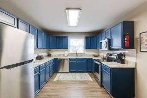 The Neighborhood House in Richmond في ريتشموند: مطبخ ازرق مع دواليب زرقاء وثلاجة