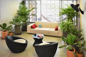 a living room with two black chairs and a couch at Color House Santa Marta in Santa Marta