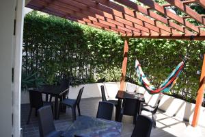 a patio with tables and chairs under a wooden pergola at Color House Santa Marta in Santa Marta