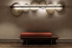 a bench with a red cushion on a wall with lights at MonAsty, Thessaloniki, Autograph Collection in Thessaloniki