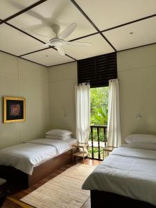 una camera con 2 letti e un ventilatore a soffitto di Sentosa Janda Baik a Kampong Sum Sum