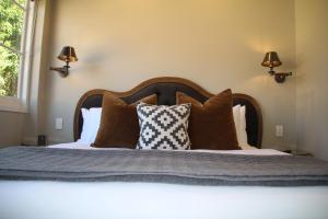 a bedroom with a large bed with brown pillows at The Houston Wagga in Wagga Wagga