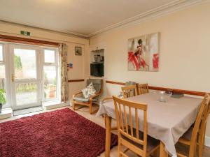 a dining room with a table and a red rug at Cairn View in Arrochar