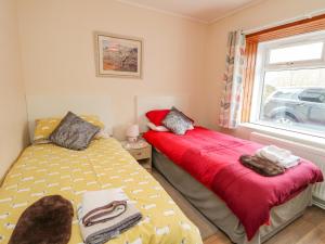 a bedroom with two beds and a window at Cairn View in Arrochar