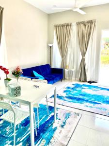 un soggiorno con divano blu e tavolo bianco di HZ HOMESTAY PENDANG a Pendang