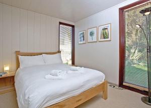 a bedroom with a bed with towels on it at Portmile Lodges in Cockwood