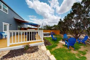 a deck with blue chairs and a table and an umbrella at Blue Getaway in Kerrville
