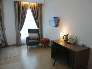 um quarto de hotel com uma secretária e uma cadeira em DSH Hotel em Kuantan