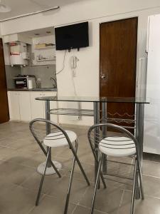 una mesa de cristal y 2 sillas en la cocina en DPTO CÉNTRICO MENDOZA en Mendoza