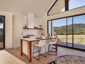 a kitchen with a table and chairs and large windows at Glenbosch Wine Estate Farm Stays in Beechworth