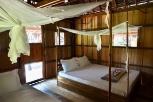 a bedroom with a bed in a wooden cabin at Lily's Riverhouse in Koh Rong Island